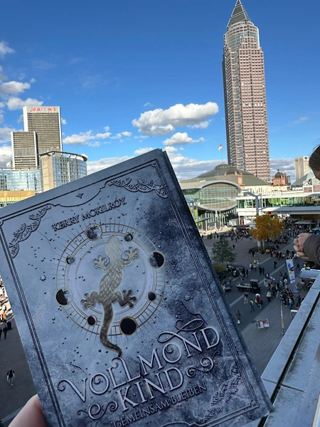 der Frankfurter Messeturm mit den Postkarten zu "Vollmondkind - Gemeinsam bleiben" im Vordergrund